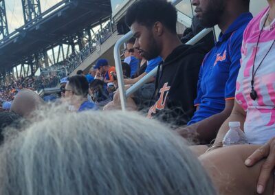 A group of people sitting in the stands at a baseball game.