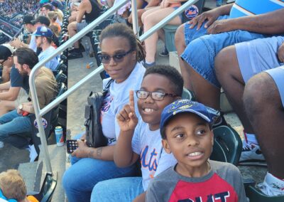 A group of people sitting in the stands at a baseball game.