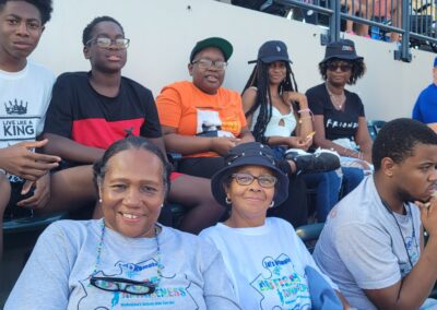 A group of people sitting in the stands at a baseball game.