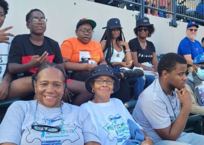 A group of people sitting in the stands at a baseball game.