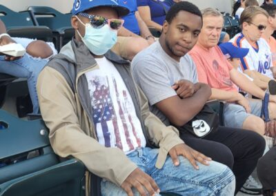 A man wearing a face mask sits in the stands.